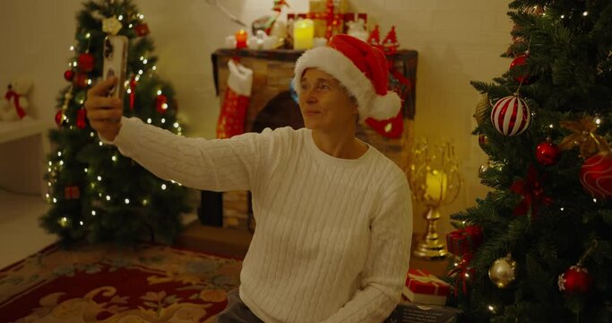 Christmas concept of 4k Resolution. Russian woman taking pictures with mobile phone at home.