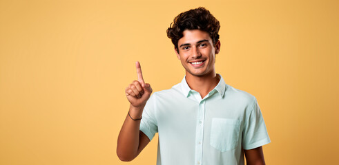 hombre joven aislado en un fondo amarillo señalando con su dedo