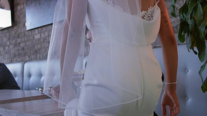 bride and groom get up out of dinner booth to leave after wedding