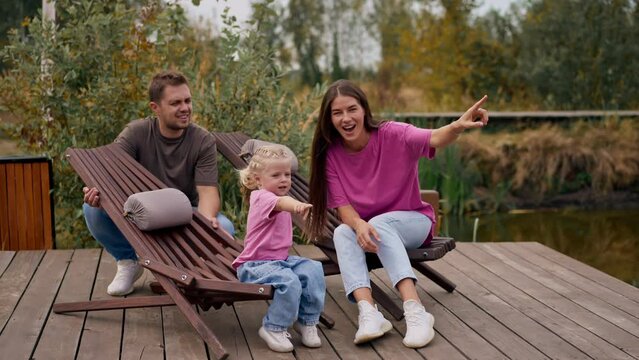 young family man and woman with their daughter walking through  forest holding hands and enjoying the beauty of nature