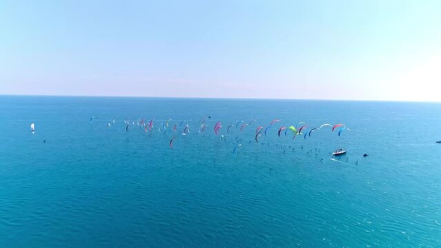 Aerial view of colorful kites above the blue sea.