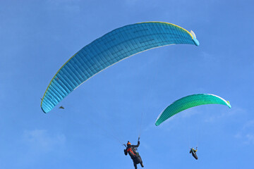 Paragliders flying in a blue sky	