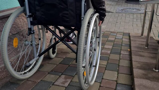 Special needs child in wheelchair learns to use wheelchairs on ramps for people with disabilities. Lifestyle of disabled children at educational age