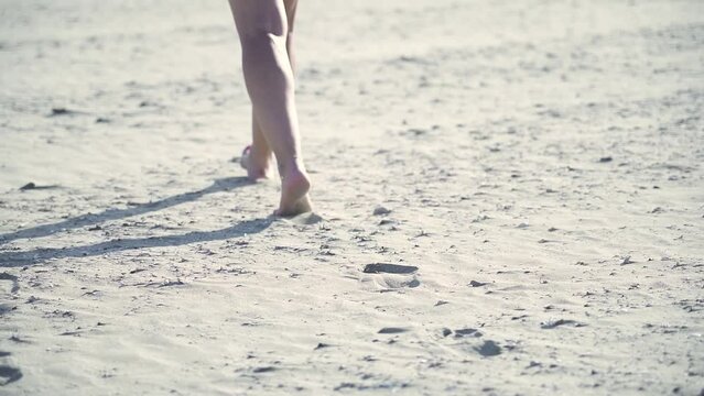 Gambe della donna che cammina sulla spiaggia