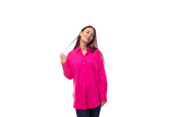 portrait of a dreamy young lady with black hair in a crimson oversized shirt on a studio white background