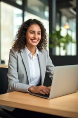 Happy young business woman entrepreneur in office using laptop at work, smiling professional female company executive wearing suit working on computer at workplace. generative AI
