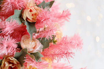 Pink Christmas tree decorated with artificial roses. Merry Christmas and New Year holidays concept. Selective focus