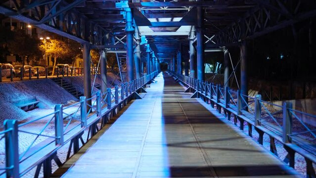 Rio Tinto Pier, also known as Muelle de Rio Tinto, Andalucia, Spain at night, with stunning lights, reflecting in dark waters of the flowing Odiel River