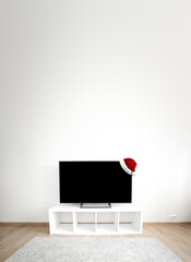 Santa Claus hat on tv on white shef at modern room interior with nobody. Christmas and new year...