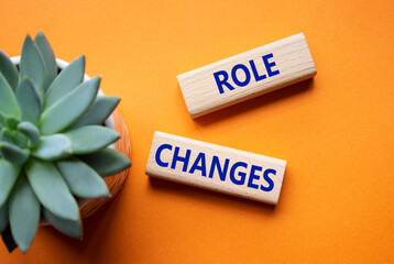Role changes symbol. Concept words Role changes on wooden blocks. Beautiful orange background with...