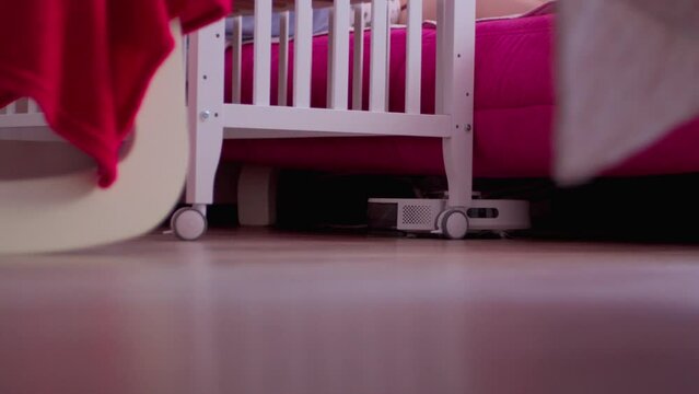 Robot vacuum cleaner cleaning the Floor Next to a Cozy Chair, children's room. Selective focus