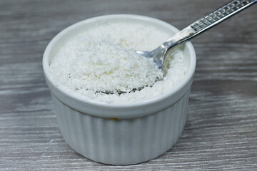 desiccated coconut in bowl on wood table