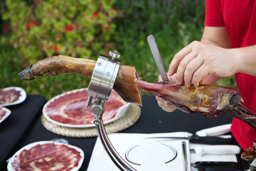 Ham slicer. Detail of the hand cutting slices of Spanish Iberian ham.