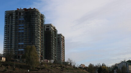 three high-rise buildings on a hill in the process of finishing construction, apartment complexes in the city, view of a site with high-rise condominiums in the last stage of construction