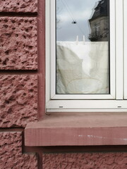 Altbau Fassade aus rotem Gestein mit Sichtschutz aus Stoff mit Wäscheklammer im Fenster eines Zimmer im Stadtteil Bornheim in Frankfurt am Main in Hessen