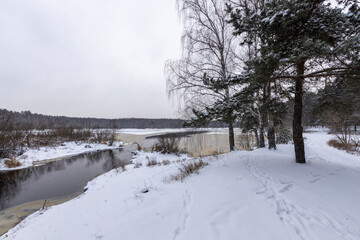 Beautiful winter landscape. Fantastic winter forest landscape, river, lake, footprints in the snow