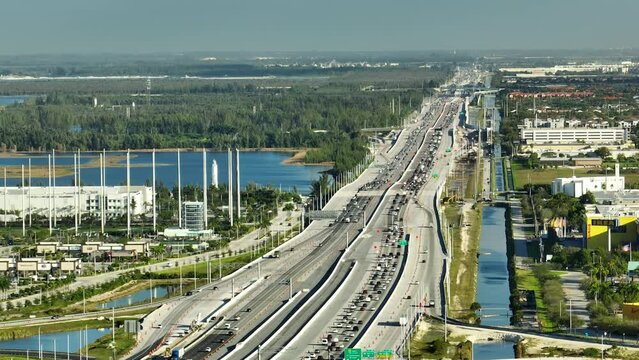 View from above of American wide freeway in Miami, Florida with dense traffic of driving cars during rush hour. USA transportation infrastructure concept