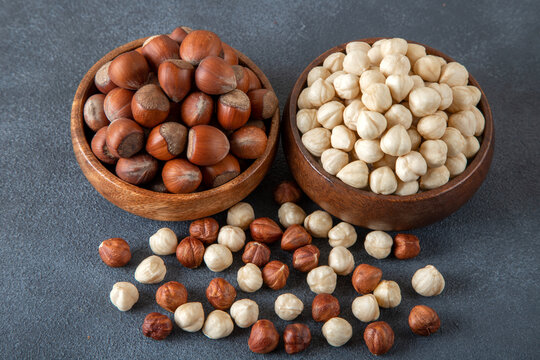 Heap of peeled and shelled hazelnuts on dark background