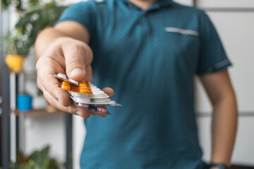 Man holding various blister pack with pills for treatment, antibiotics or painkiller medicine,...
