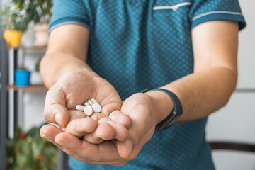 Man holding in a hand various therapeutic pills, antibiotics, painkiller, medicine, close-up view