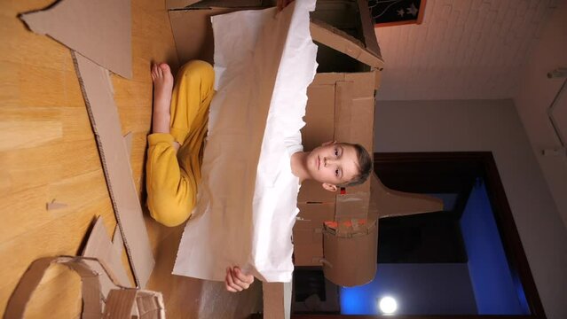 vertical video boy builds a spaceship out of cardboard