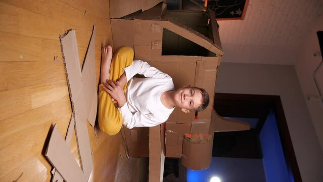 vertical video boy builds a spaceship out of cardboard
