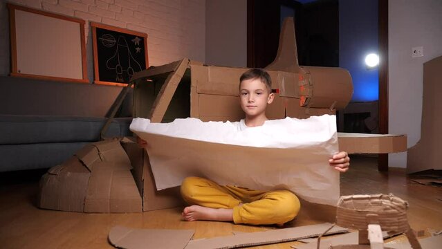 boy builds a spaceship out of cardboard