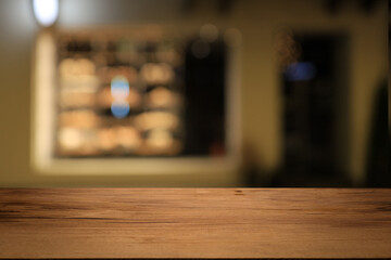 Beautiful empty wood table top counter, window view. Wooden table with blur bokeh background ready for product montage. Abstract blurred bokeh neutral background of city, shop, store, restaurant, city