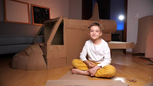 boy builds a spaceship out of cardboard