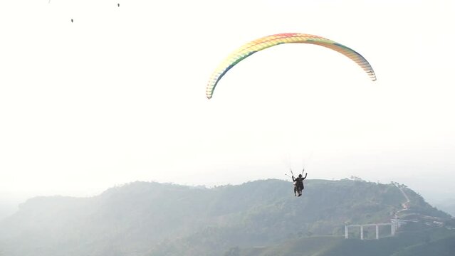 Local tourists enjoy skydiving while taking a paragliding tour in Karanganyar, Indonesia