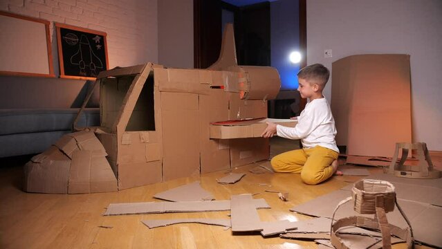 boy builds a spaceship out of cardboard