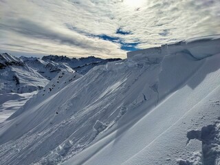 Avalanche snow cornice. Be careful of snow cornices on the mountain ridge. Avalanche went down. Girenspitz Schafberg St.Antönien. High quality photo