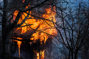 Burning wooden house. Blaze fire flame home. House fire. Burning building. Open flames. Fire in the house.