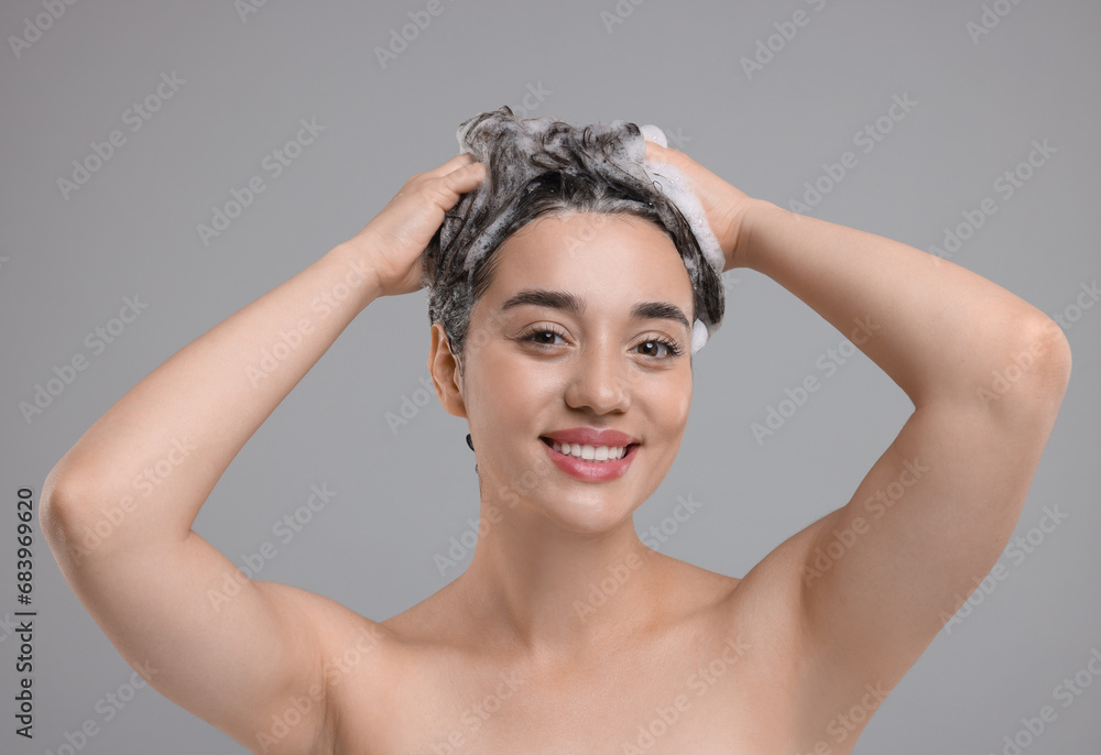 Sticker Portrait of beautiful happy woman washing hair on grey background