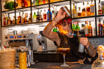 Bartender flaming the decoration of a cocktail