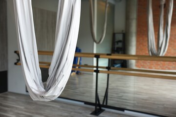 Many hammocks for fly yoga in studio, space for text