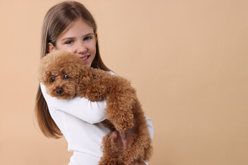 Little child with cute puppy on beige background, space for text. Lovely pet