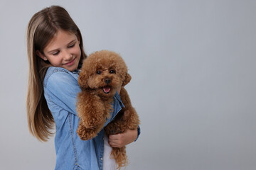 Little child with cute puppy on light grey background, space for text. Lovely pet