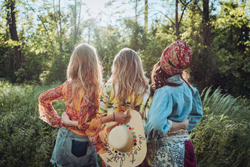 three girls female friends hugging in nature from behind 