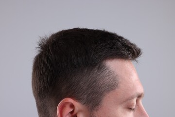 Man with healthy hair on grey background, closeup