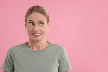 Embarrassed woman on pink background. Space for text - obrazy, fototapety, plakaty