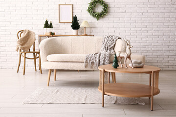 Interior of festive living room with white sofa, coffee table and Christmas decorations