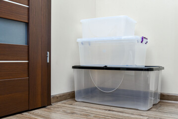 Empty plastic storage boxes stacked on the floor of the room