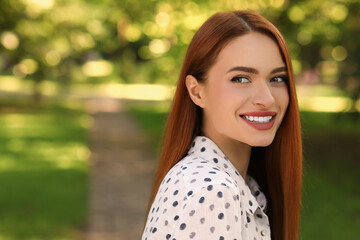 Portrait of happy young woman outdoors. Space for text. Attractive lady smiling and posing for camera