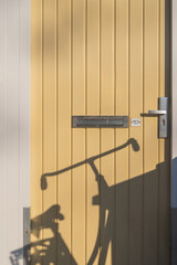 Silhouette of a bike on a yellow entrance door