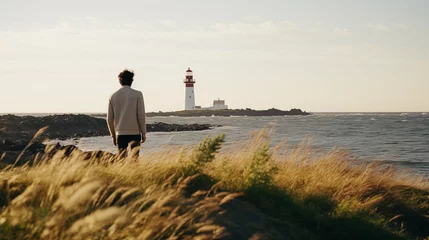 Tuinposter Lighthouse and man. Man walks near the lighthouse and enjoy beautiful nature landscape. Lonely male. Scenic northern outdoors view. Travel and adventure. Explore North. Generated AI © Iuliia Pilipeichenko