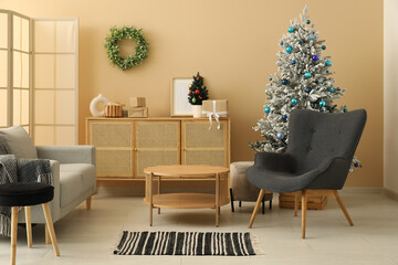 Interior of living room with decorated Christmas tree, dresser and armchair