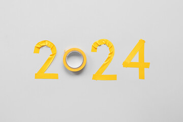 Figure 2024 made of adhesive tape on grey background