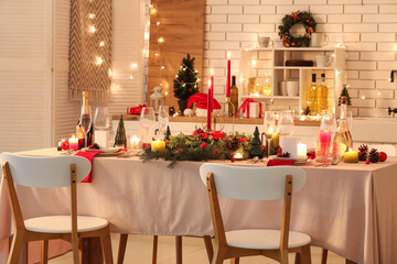 Festive table setting with Christmas decorations and glowing lights in kitchen at evening