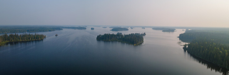 Aerial view of a large northern lake that has many small islands. The area is heavily treed with...